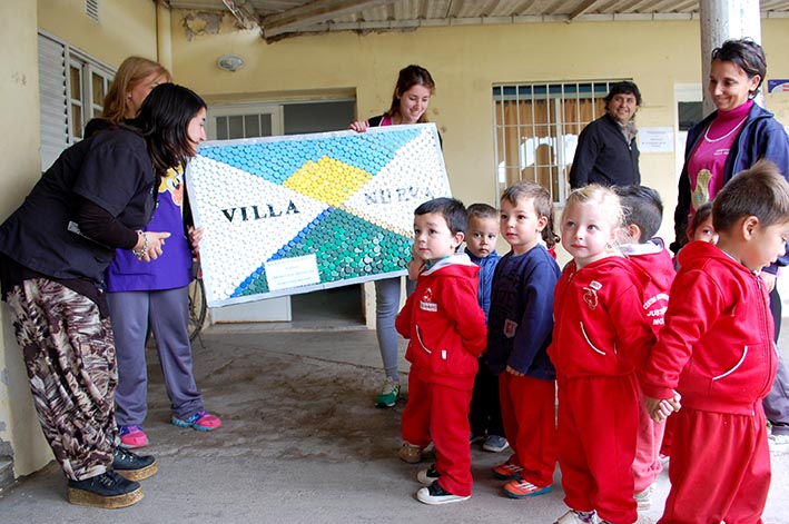 Hicieron la bandera de la ciudad con tapitas y se la dieron al municipio