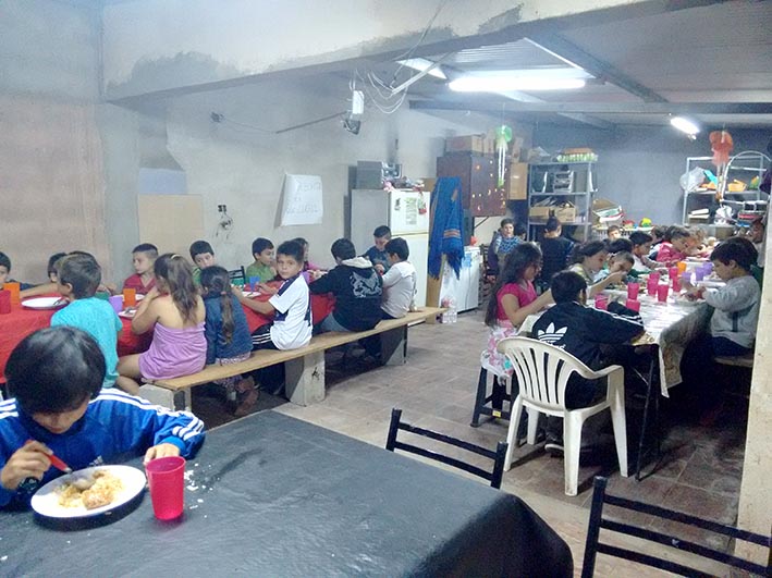 Récord de chicos que buscan un plato de comida en un comedor