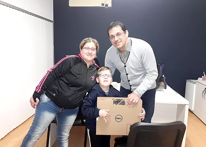 Ayudan a un niño a tener su computadora