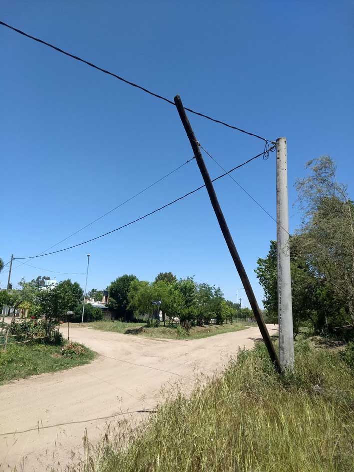 Frentistas preocupados por un poste a punto de tumbarse