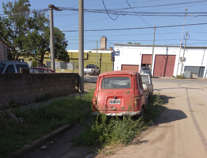 Dos autos abandonados y basura en un sitio baldío